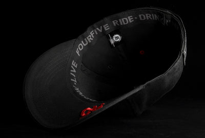 A Fourfive 45 Knight Racer hat with curved brim in all black stretch fit material flipped over showing the red 45 logo embroidery detail on the bottom of the brim and the ride drink live embroidery detail around the sweat band on the inside of the hat.  Built to fit normal and big heads.