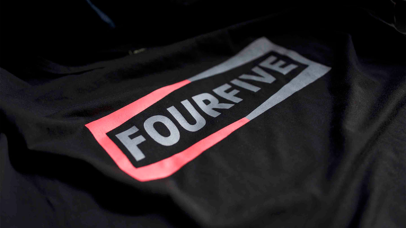 A Fourfive 45 black Champ t shirt close up of the Fourfive champ graphics at a 45 degree angle with dramatic lighting.