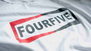 A Fourfive 45 white Champ t shirt close up of the Fourfive champ graphics at a 45 degree angle with dramatic lighting.