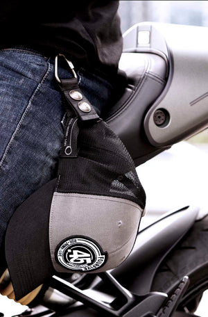 FOURFIVE 45 CURVED BRIM GREY AND BLACK SNAP BACK FLAT TRACKER TRUCKER HAT SECURED TO HAT HOLSTER OF RIDER SITTING ON DUCATI MONSTER 