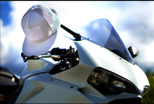 Fourfive white flat brim snap back customizer hat hanging on mirror of white ducati panagale in the summer light.